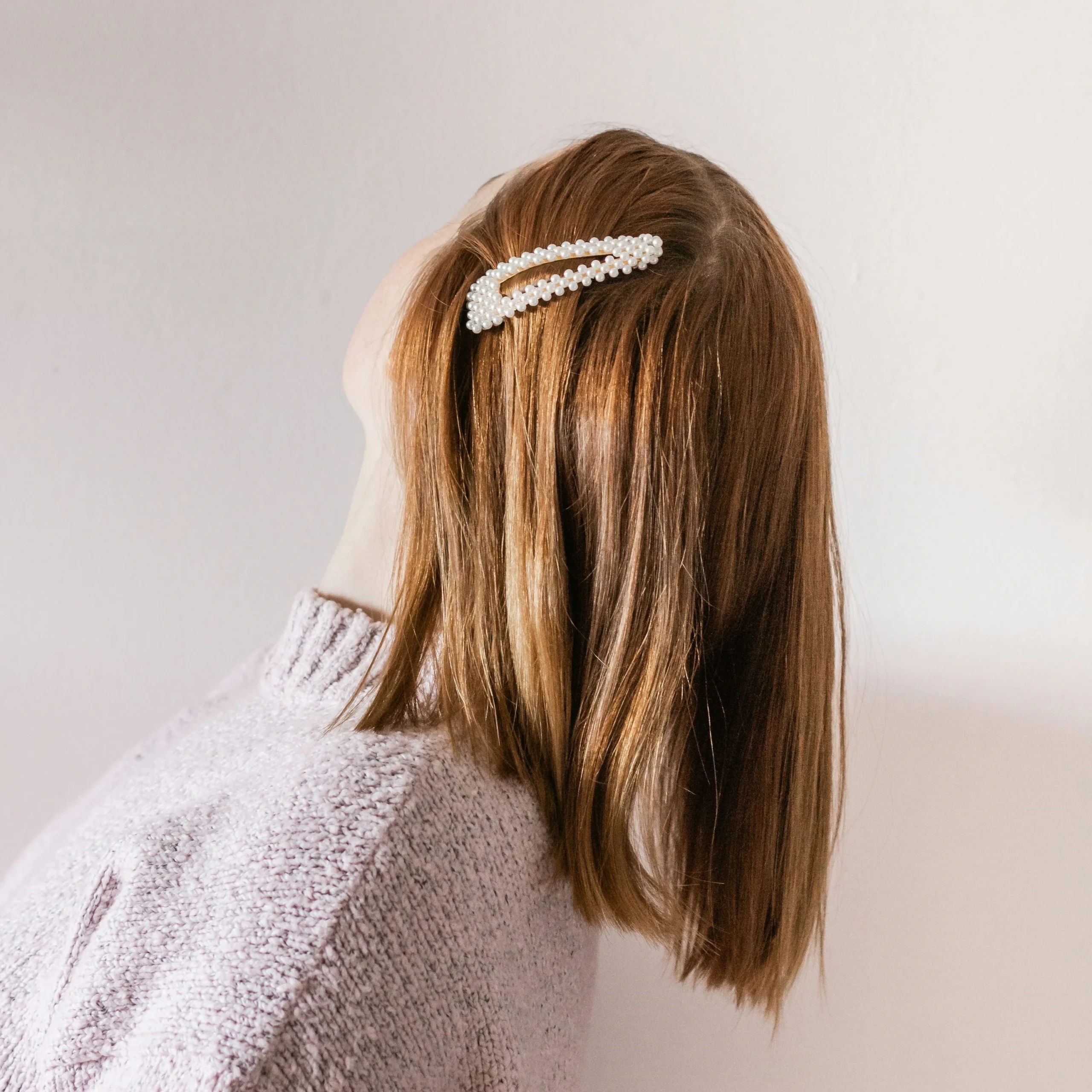 Girl with hair accessory with pearls attach with cream glue