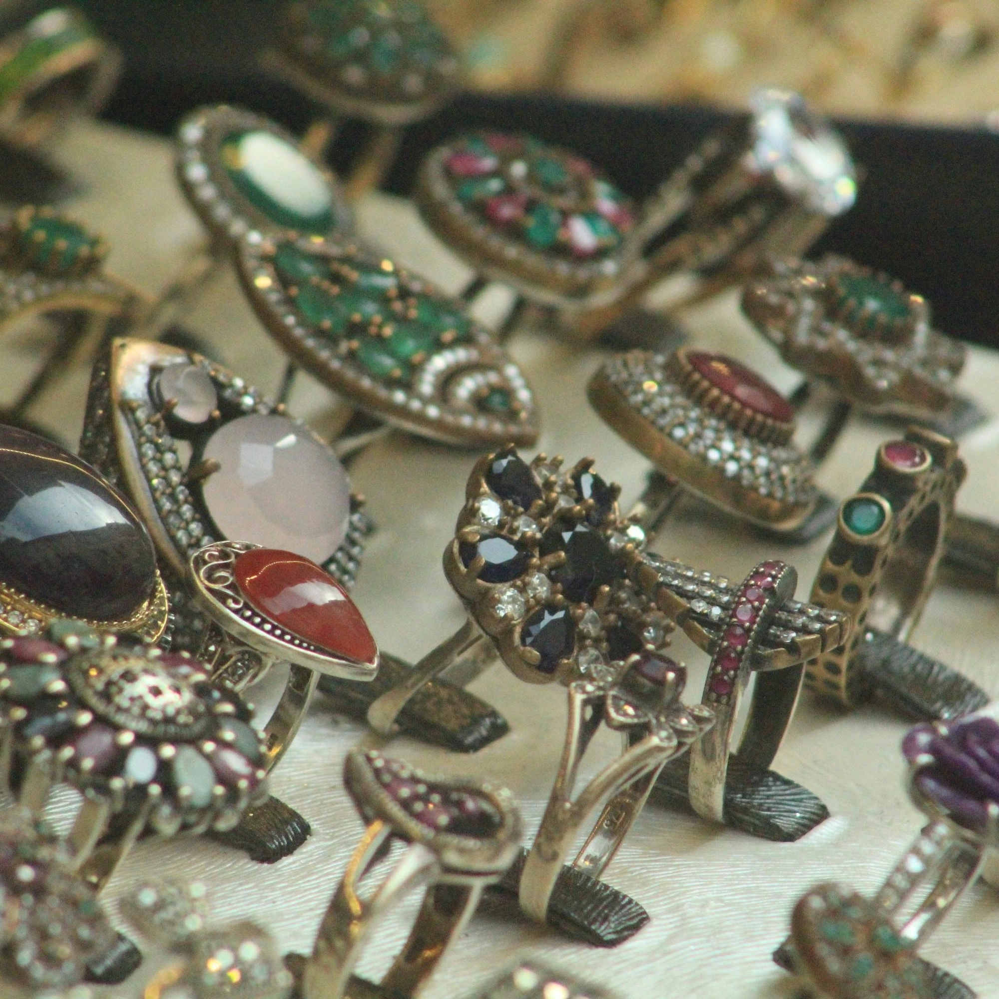 lots of rings with colorful stones attached through cream glue