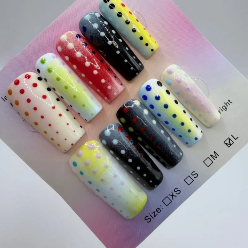 Glossy long press-on nails featuring colorful polka dot designs over gradient pastel and dark backgrounds, displayed on a size chart card.