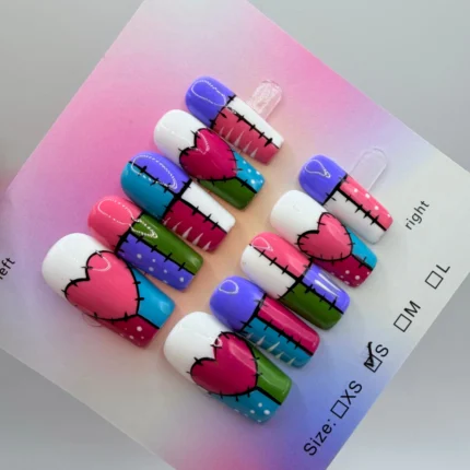 Colorful patchwork nail set with stitched heart design and bold contrasting tips.