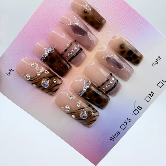 Handmade Brown Animal Print Press-On Nails Handmade brown animal print press-on nails with 3D gold accents and rhinestones in square and coffin shapes.