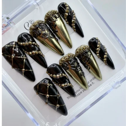 Luxury baroque gothic press on nails featuring matte black textures and intricate handpainted gold trim.
