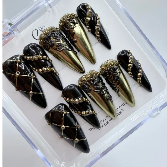 Luxury baroque gothic press on nails featuring matte black textures and intricate handpainted gold trim.