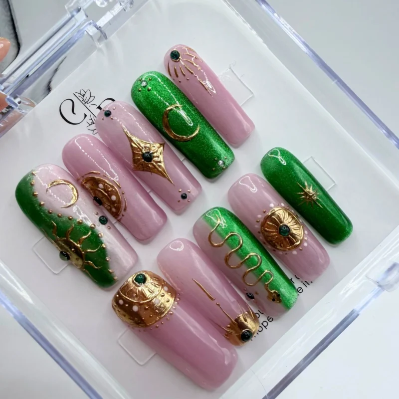 Luxury celestial press on nails featuring an emerald blush color melt with delicate gold stars.