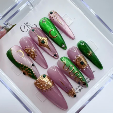 Handmade emerald celestial press on nails featuring a deep green base with handpainted gold stars and moons.