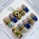 Luxury vintage baroque press on nails with intricate handpainted 3D gold filigree and metallic detailing.