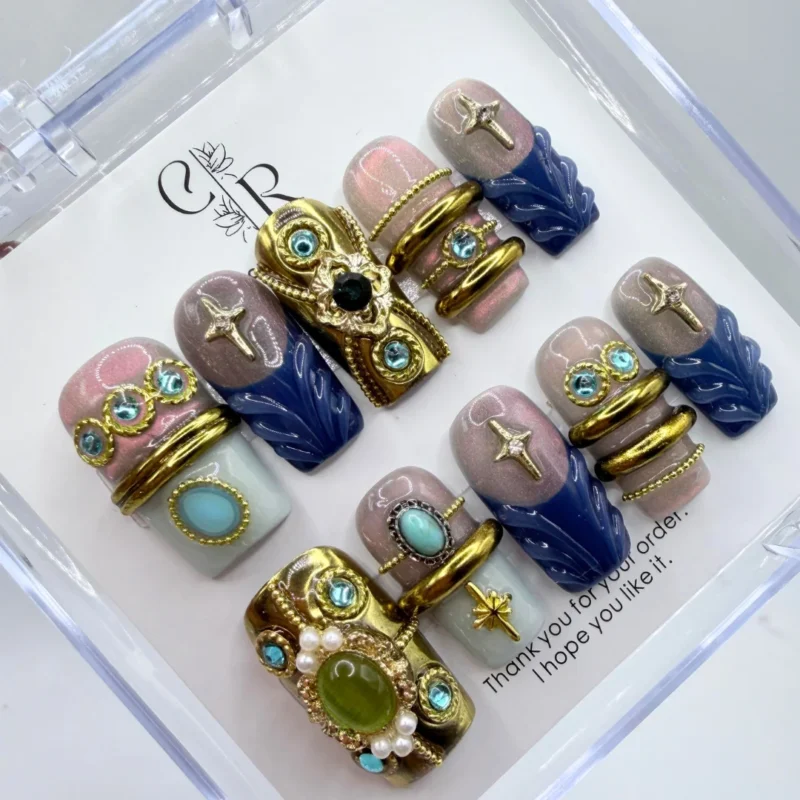 Luxury vintage baroque press on nails with intricate handpainted 3D gold filigree and metallic detailing.